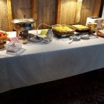 table with white tablecloth filled with breakfast foods