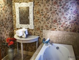 bathroom with floral wallpaper and tub