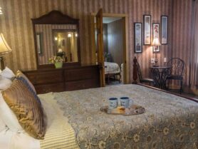 bedroom with 4 poster bed, brown striped wallpaper