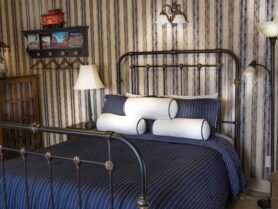 iron bed with blue bedspread