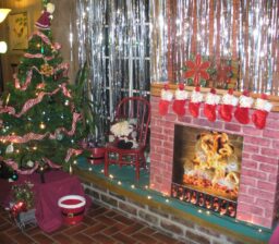 Christmas tree next to fake fireplace