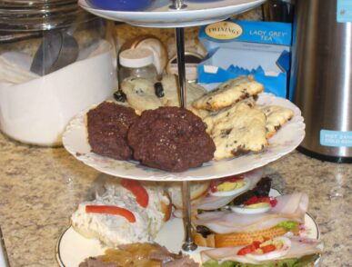 Three tiered china serving tray filled with savory ands sweet items