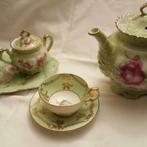 green and pink teapot, cup, saucer, creamer and sugar