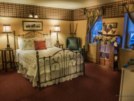 bedroom with iron bed with white and red bedspread