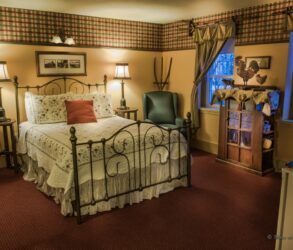 bedroom with iron bed with white and red bedspread