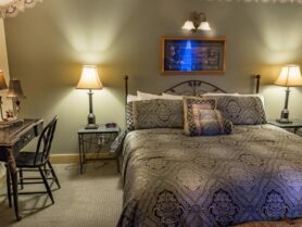 bed with brown bedspread, desk and chair