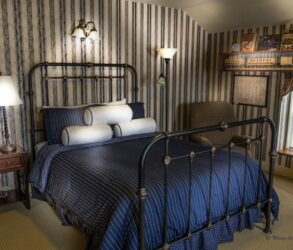 iron bed with blue bedspread