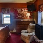 The Major Leaguer room with bed, chest of drawers, comfy chair and small fridge